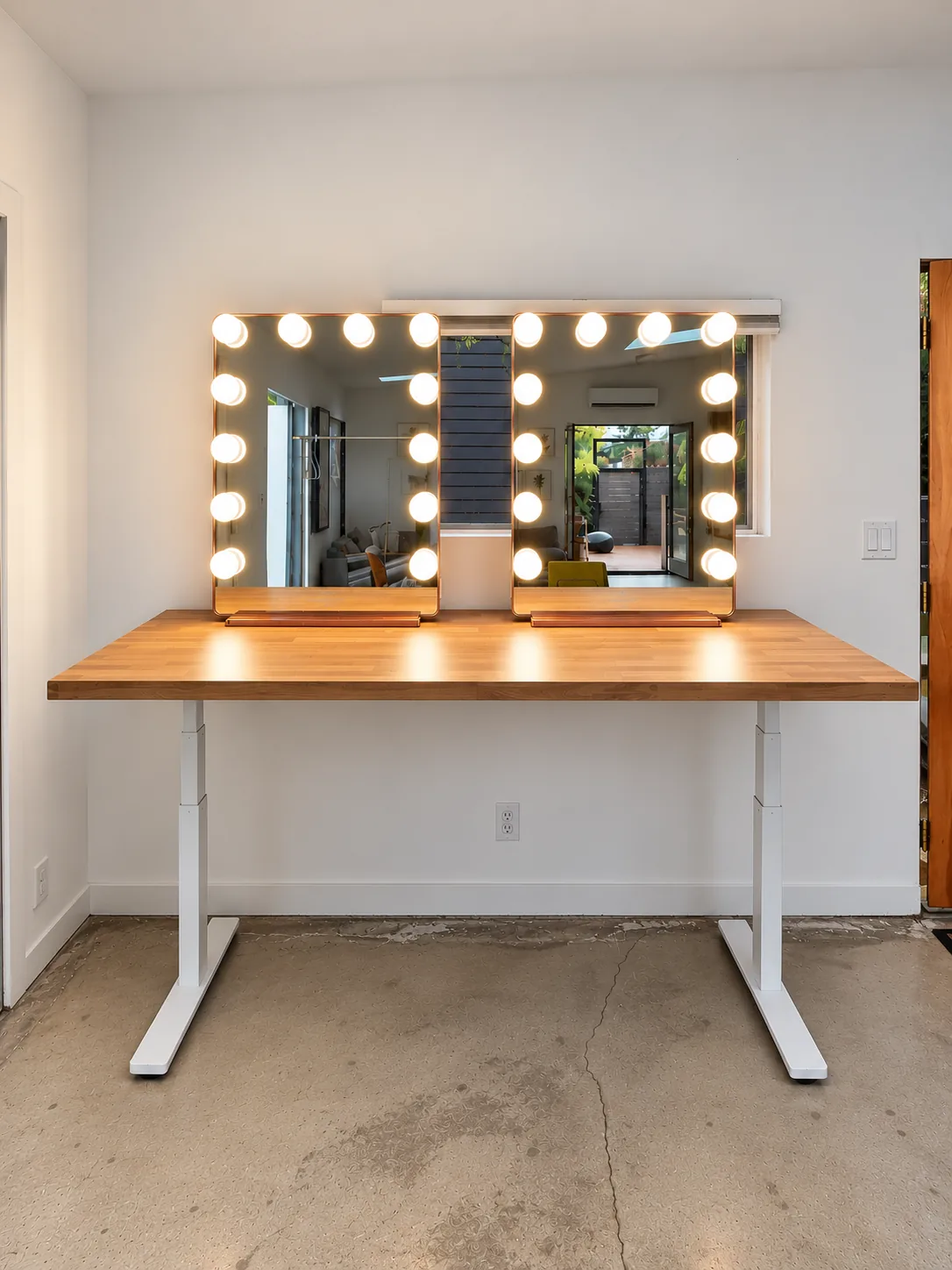 Hair and makeup station with two large vanity mirrors and adjustable desk